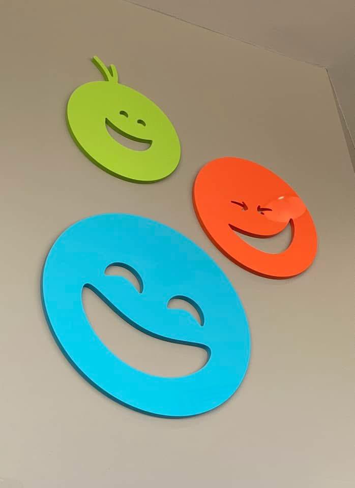 Three cheerful smiley face wall decals in green, orange, and blue